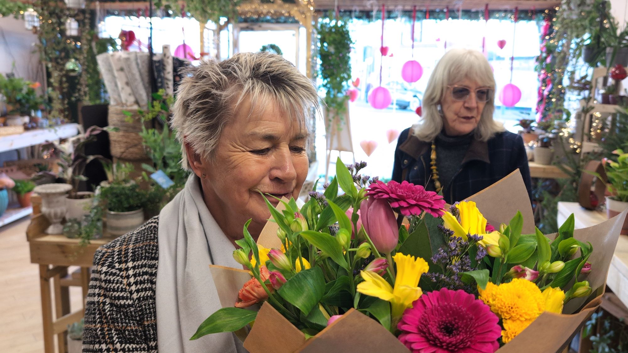 Two shoppers look at the bouquets on offer at the florists